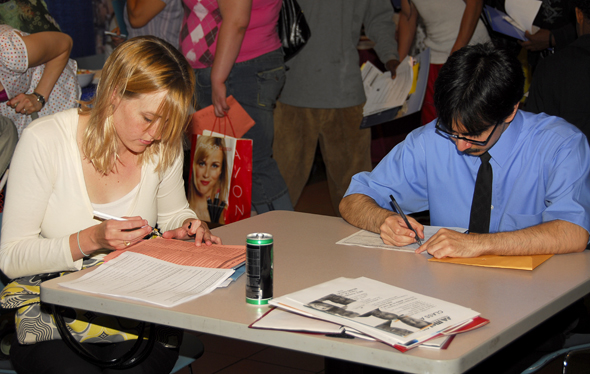 Work Fair attendees fill out job applications.