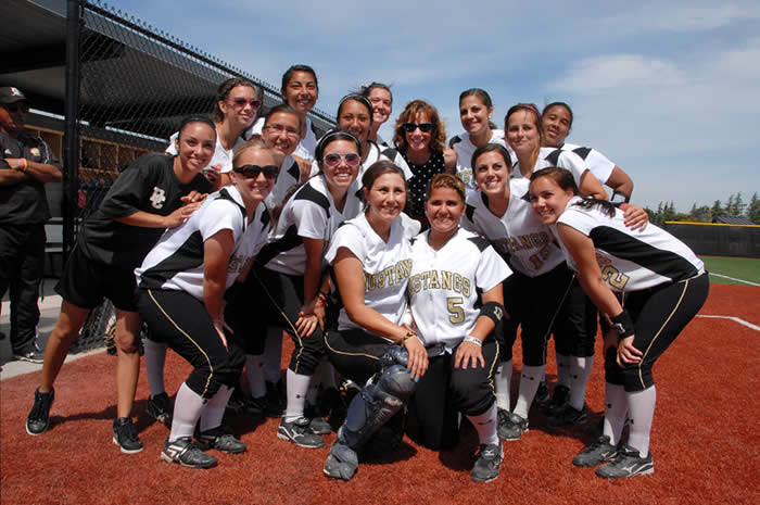 Cindy Layland poses with Delta's Lady Mustangs Softball Team.