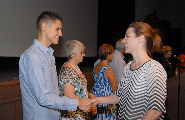 Alejandro Gomez congratulates a scholarship winner at last year's ceremony.