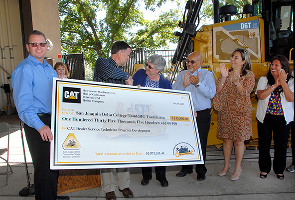 Caterpillar Officials present a check for $135,000 to Dr. Kathy Hart and Delta College Trustees.