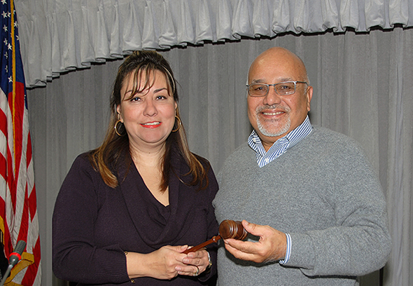 Claudia Moreno accepts the gavel from Steve Castellanos.