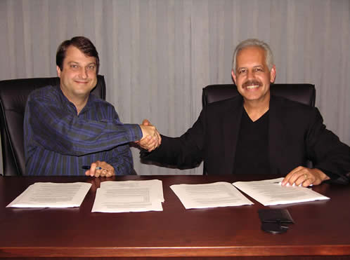 Gerry Kamilos, and Dr. Raul Rodriguez, shake hands.